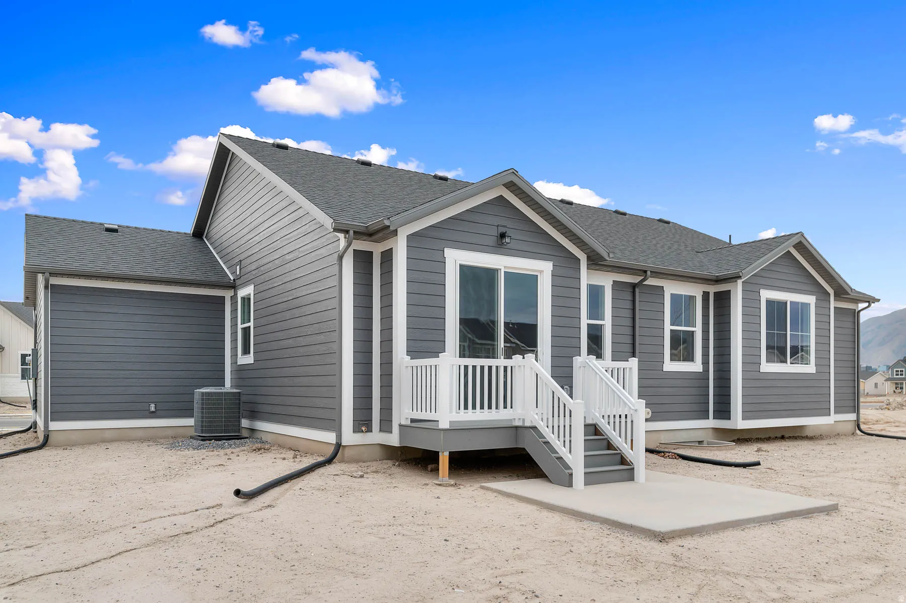 Contemporary ranch-style residence featuring grey horizontal siding and white trim
