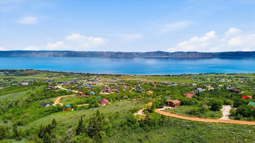 Expansive lakefront community with homes nestled among green hillsides