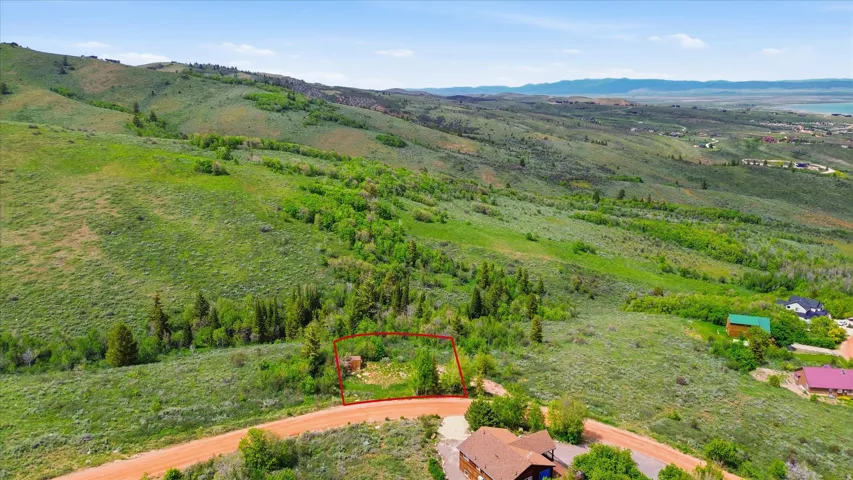 Expansive lot on a hillside with natural vegetation and distant water feature