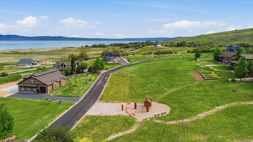 Spacious property featuring expansive green lawns, paved private roads, and a playground structure