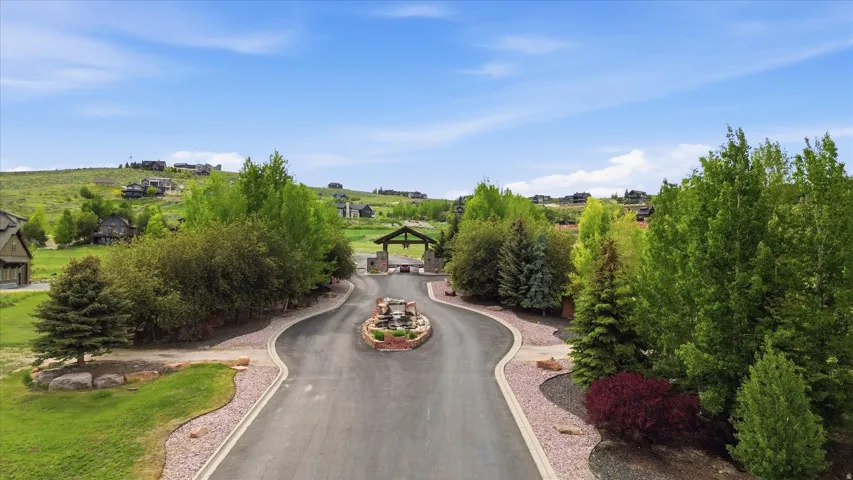 Curved paved driveway with a central stone-clad water feature