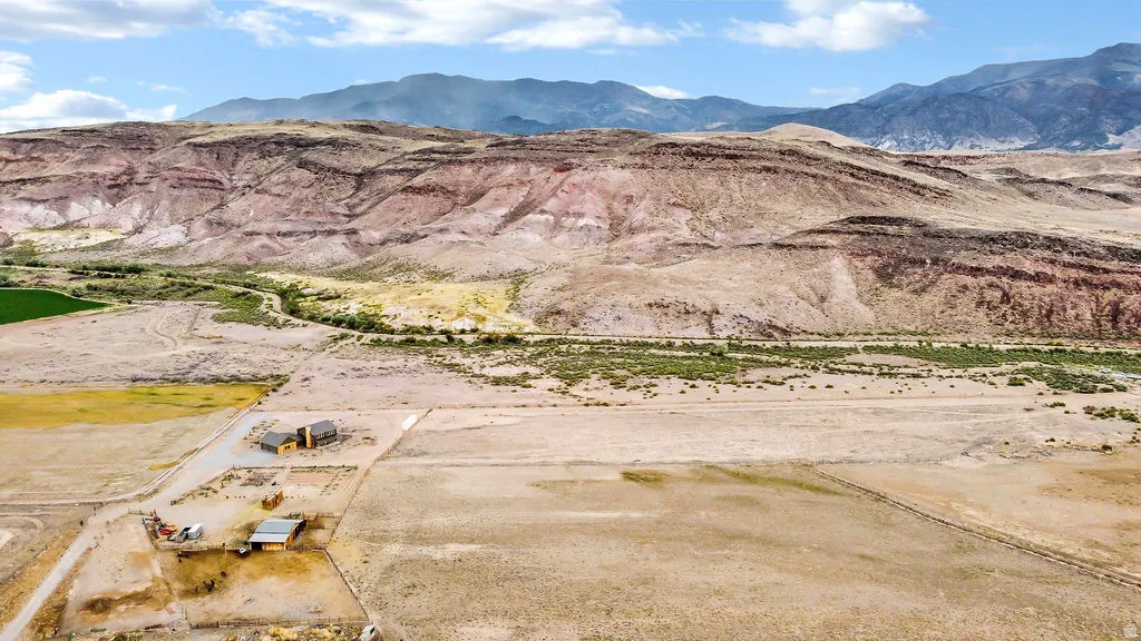 Expansive desert landscape featuring a central property with multiple structures, including a primary residence and outbuildings