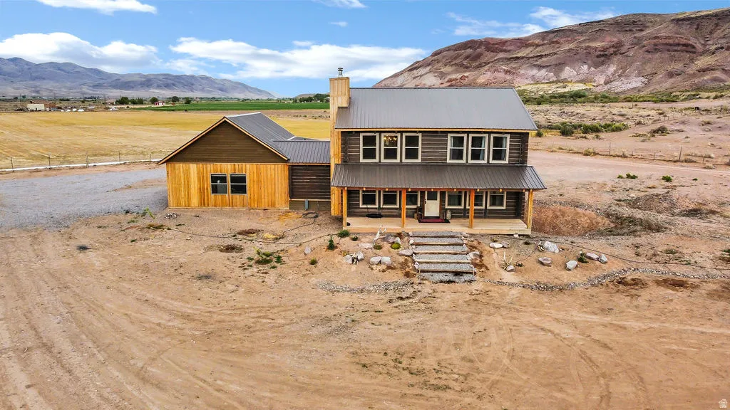 Rustic-style residence featuring a metal roof, wood siding, and an inviting covered porch