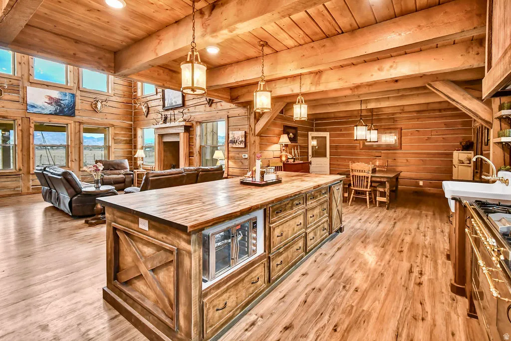 Open concept living area featuring exposed wood beam ceilings and wood-finish flooring