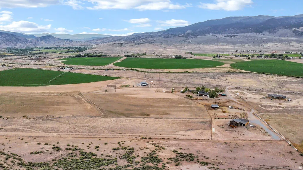 Expansive rural landscape featuring distant mountain ranges and scattered agricultural fields