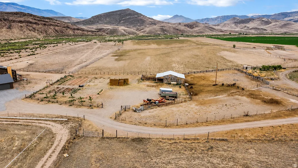 Sprawling rural property featuring open land, a large barn, and surrounding mountainous terrain