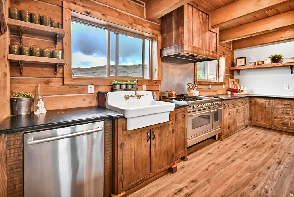 Spacious kitchen featuring wood-finish flooring, custom wood cabinetry, and exposed wood ceiling beams