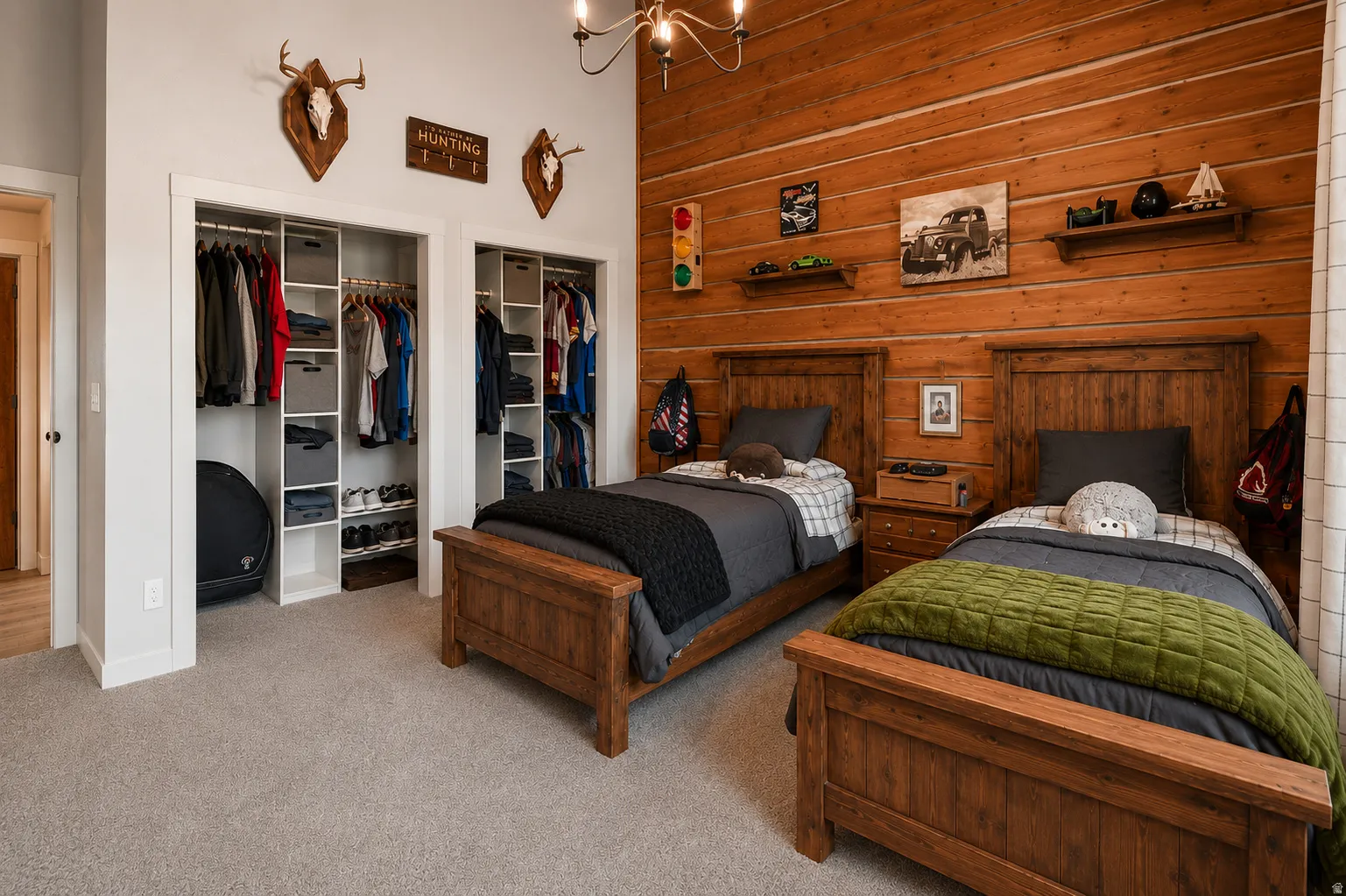 Interior room featuring a wood-paneled accent wall, two separate built-in closets with storage systems, and light-toned carpet flooring