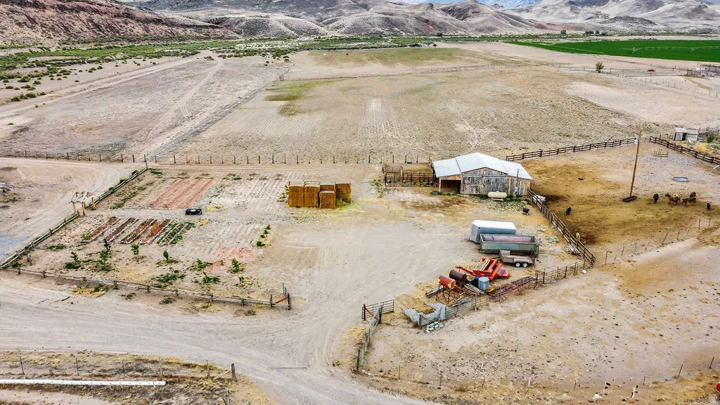 Expansive property featuring a large barn, fenced agricultural plots, and a spacious corral area