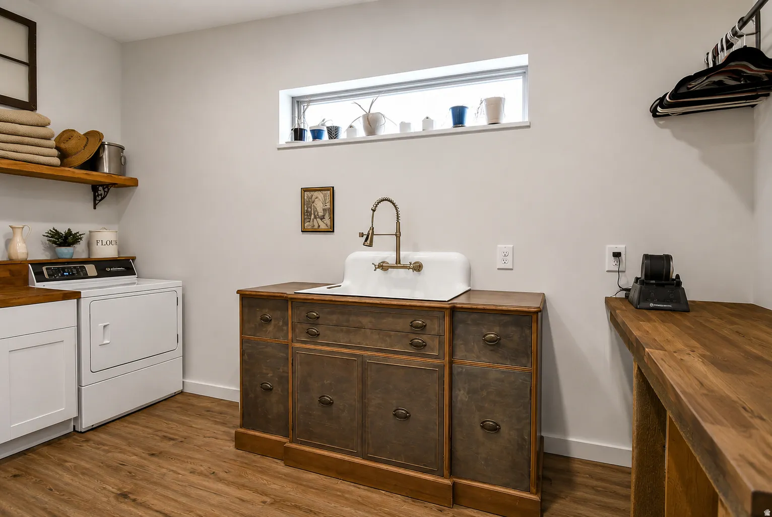 Dedicated laundry area featuring wood-finish flooring and light gray walls
