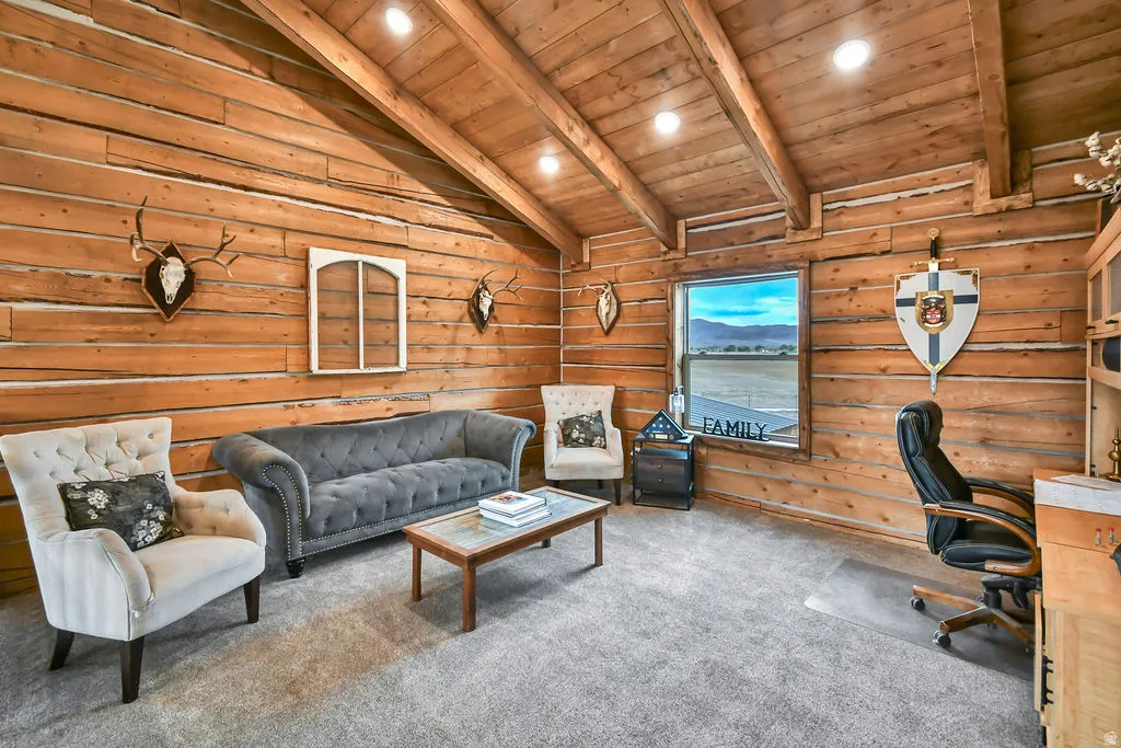 Rustic wood-paneled walls and ceiling featuring exposed beams, recessed lighting, and expansive window with distant mountain scenery
