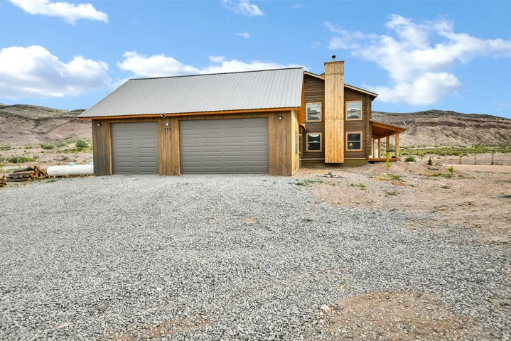 Two-car garage with wood siding and a metal roof