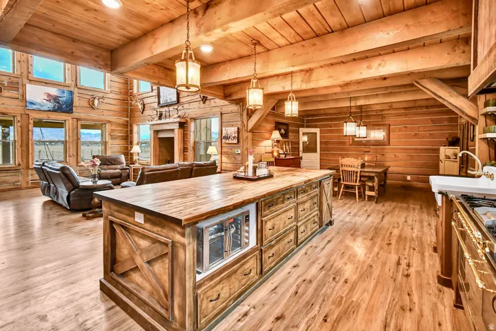 Open concept living area featuring exposed wood beam ceilings and wood-finish flooring