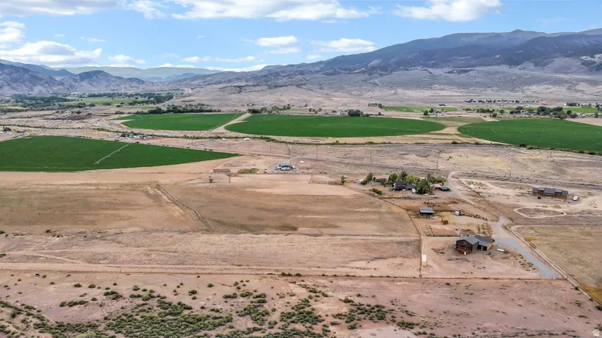 Expansive rural landscape featuring distant mountain ranges and scattered agricultural fields