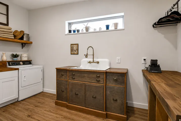 Dedicated laundry area featuring wood-finish flooring and light gray walls