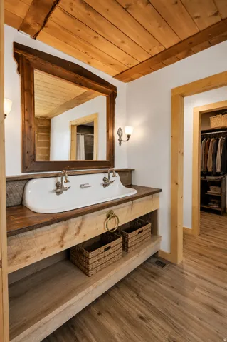 Bathroom featuring a rustic wood vanity with integrated double sink and dual wall-mounted faucets