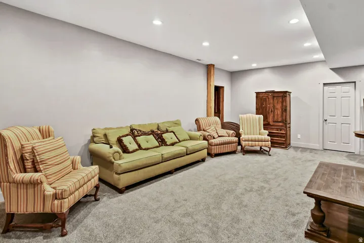Spacious room featuring light gray walls, recessed lighting, and gray carpeting