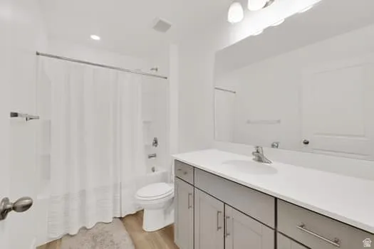 Bathroom featuring a single vanity with a white countertop, under-mount sink, and gray cabinetry