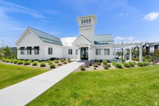 White-sided building featuring a prominent cupola and a green metal roof