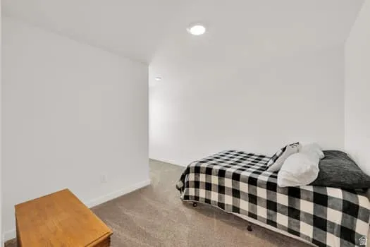 Carpeted room featuring white walls and recessed lighting