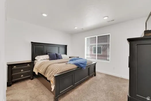 Carpeted bedroom featuring white walls and recessed lighting
