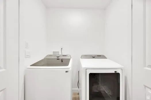 Dedicated laundry area featuring white walls, a top-load washing machine, and a front-load dryer