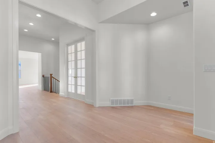 Spacious interior featuring wood-finish flooring, white walls, and recessed lighting