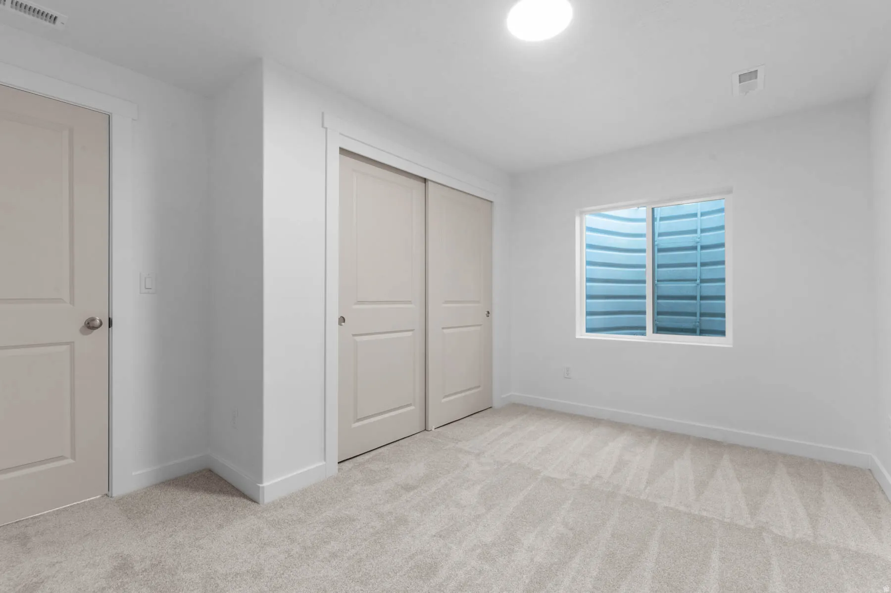 Bright white walls and trim complement the light-toned carpet