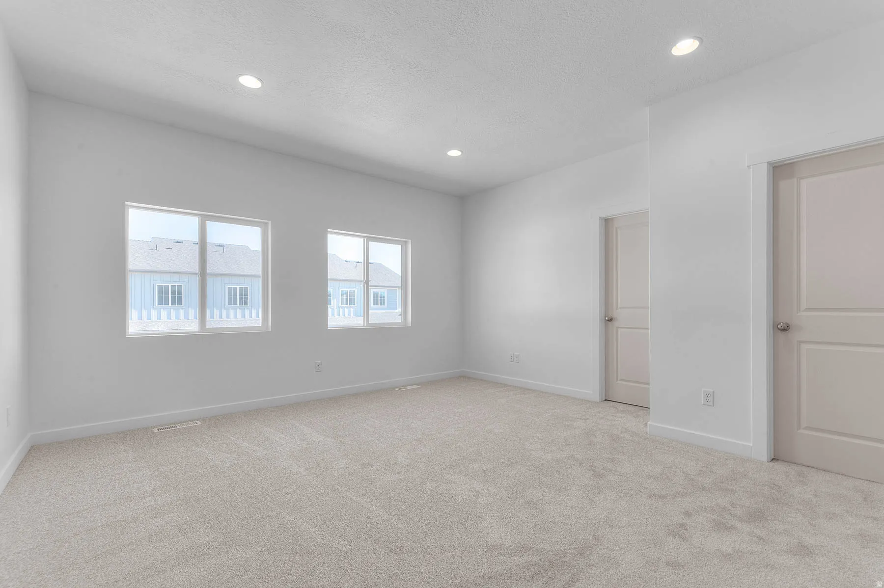 Spacious room featuring neutral carpeting and white painted walls