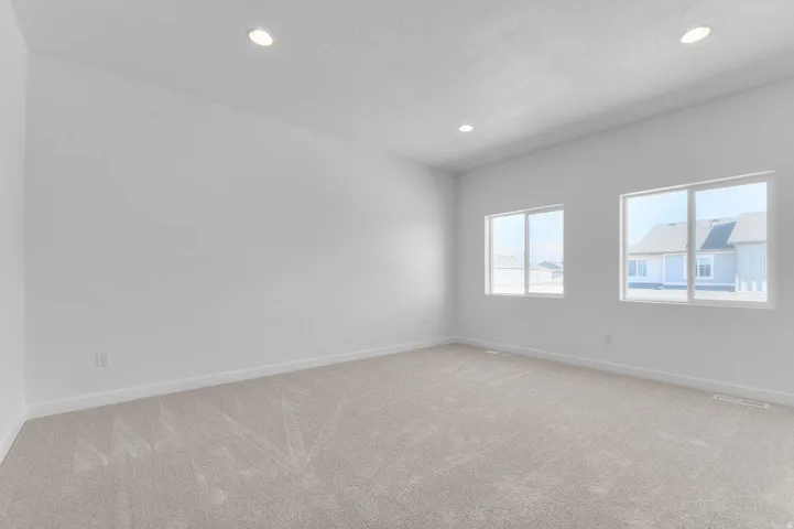 Spacious room featuring neutral carpeting and white walls