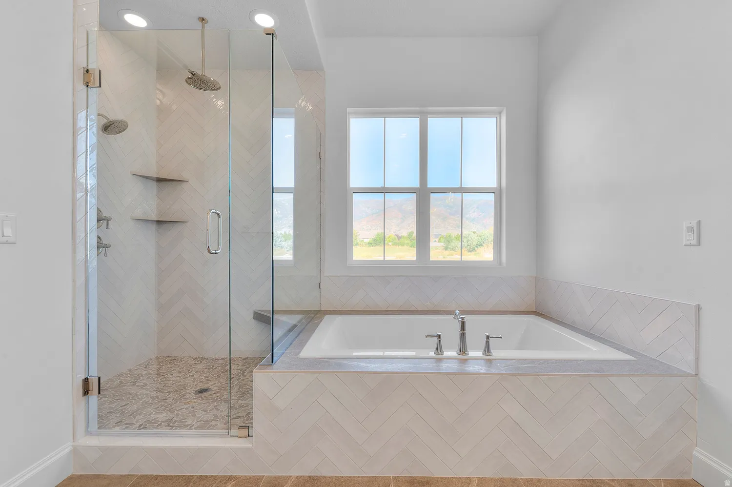 Contemporary bathroom featuring a spacious glass-enclosed shower with pebble-finish flooring and dual showerheads