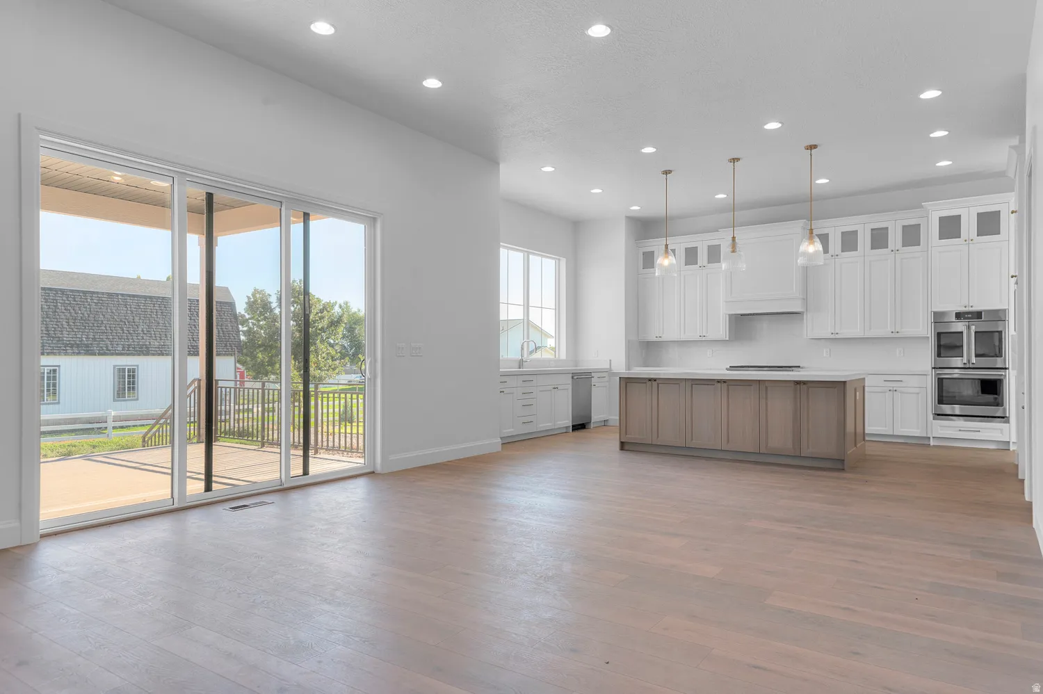 Spacious kitchen and living area featuring wood-finish flooring and recessed lighting