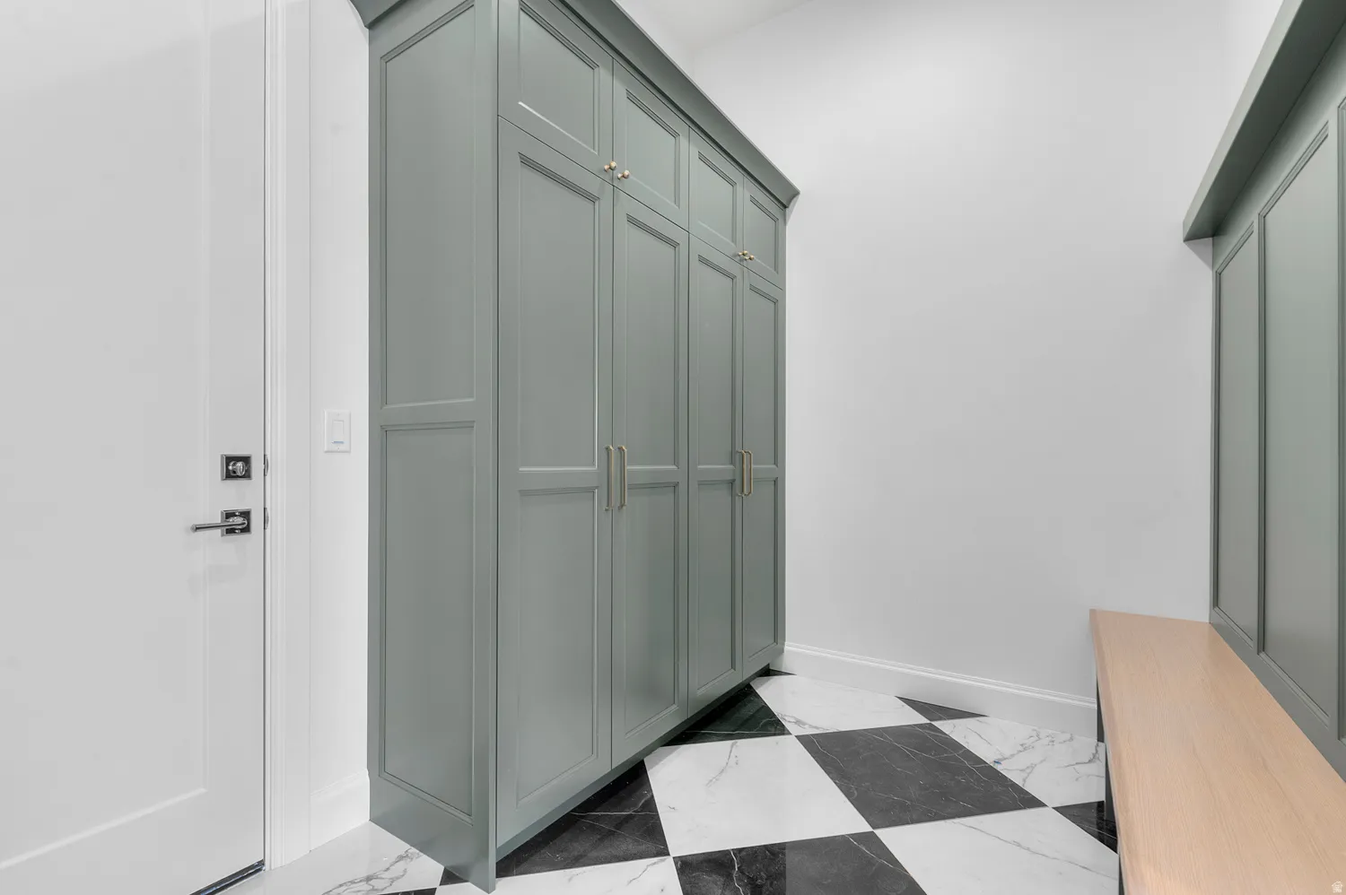 Entryway with tall built-in cabinetry and a wood-finish bench
