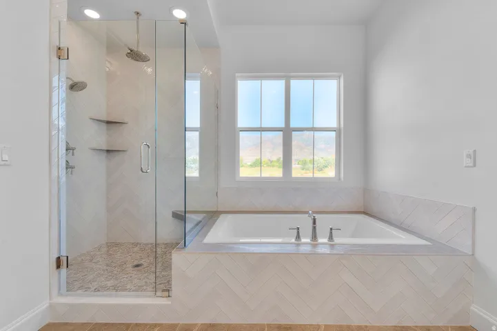 Contemporary bathroom featuring a spacious glass-enclosed shower with pebble-finish flooring and dual showerheads