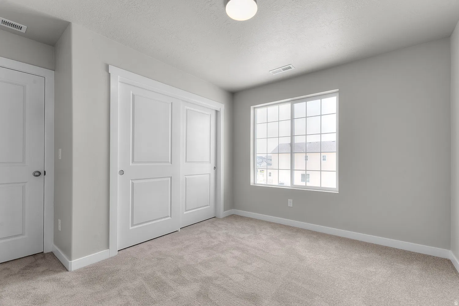 Carpeted room with light grey walls and white trim
