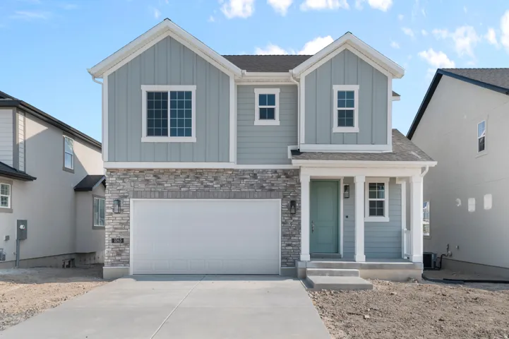 Contemporary two-story residence featuring light blue vertical siding and stone veneer accents