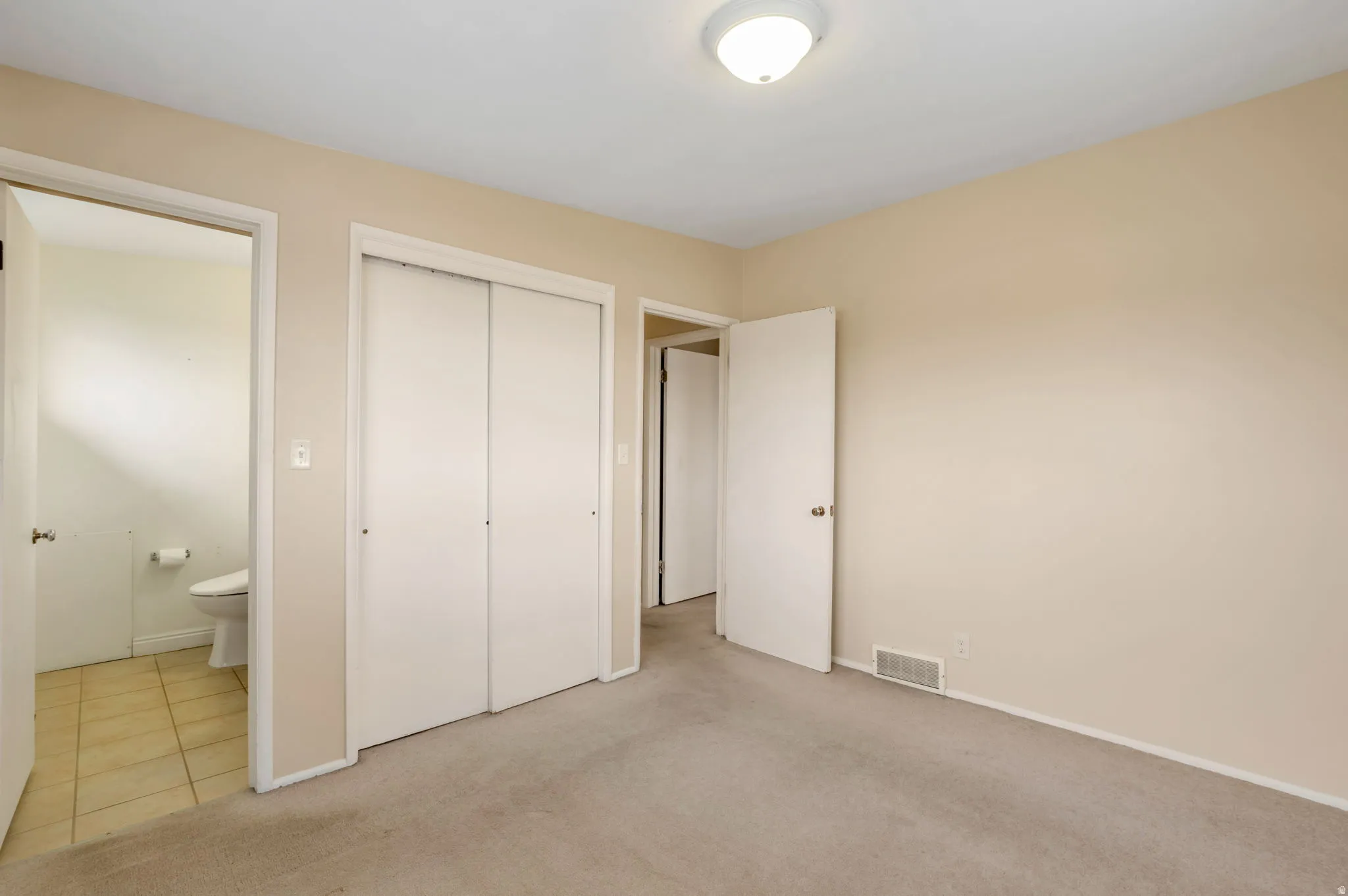 Carpeted room with neutral wall tones and a ceiling-mounted light fixture