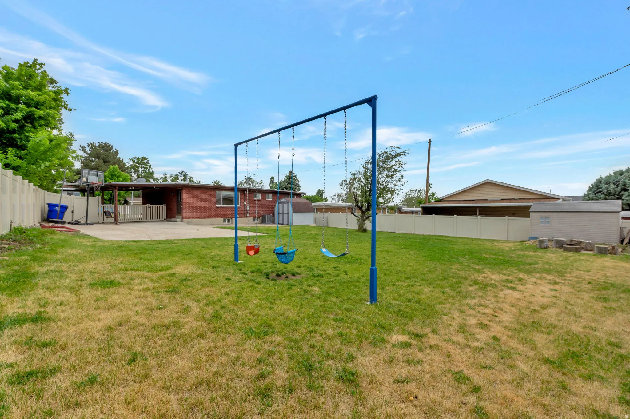 Expansive backyard featuring a grass lawn, a paved patio, and a privacy fence
