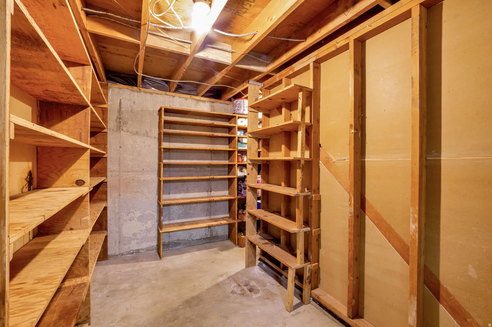 Utility space featuring exposed wood ceiling joists and unfinished concrete flooring