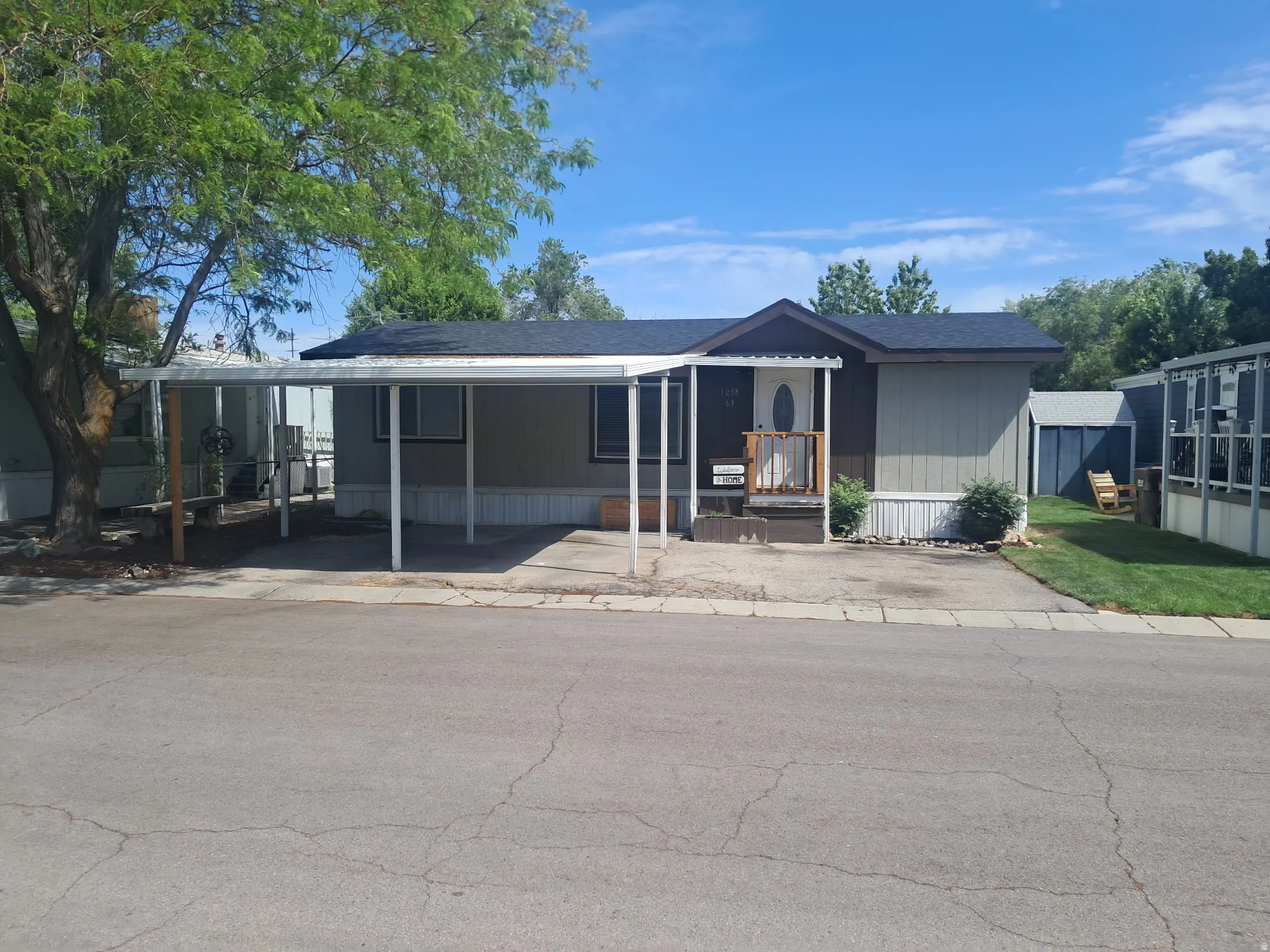 Modular home with a covered carport, porch entry, and shingled roof