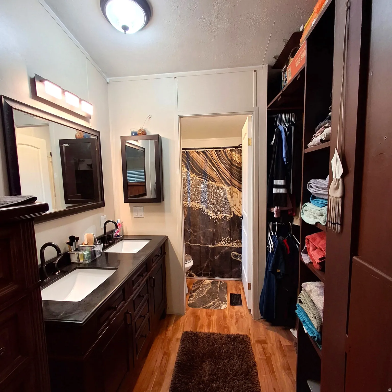 Bathroom featuring a double vanity with dark wood-finish cabinetry, white sinks, and black faucets