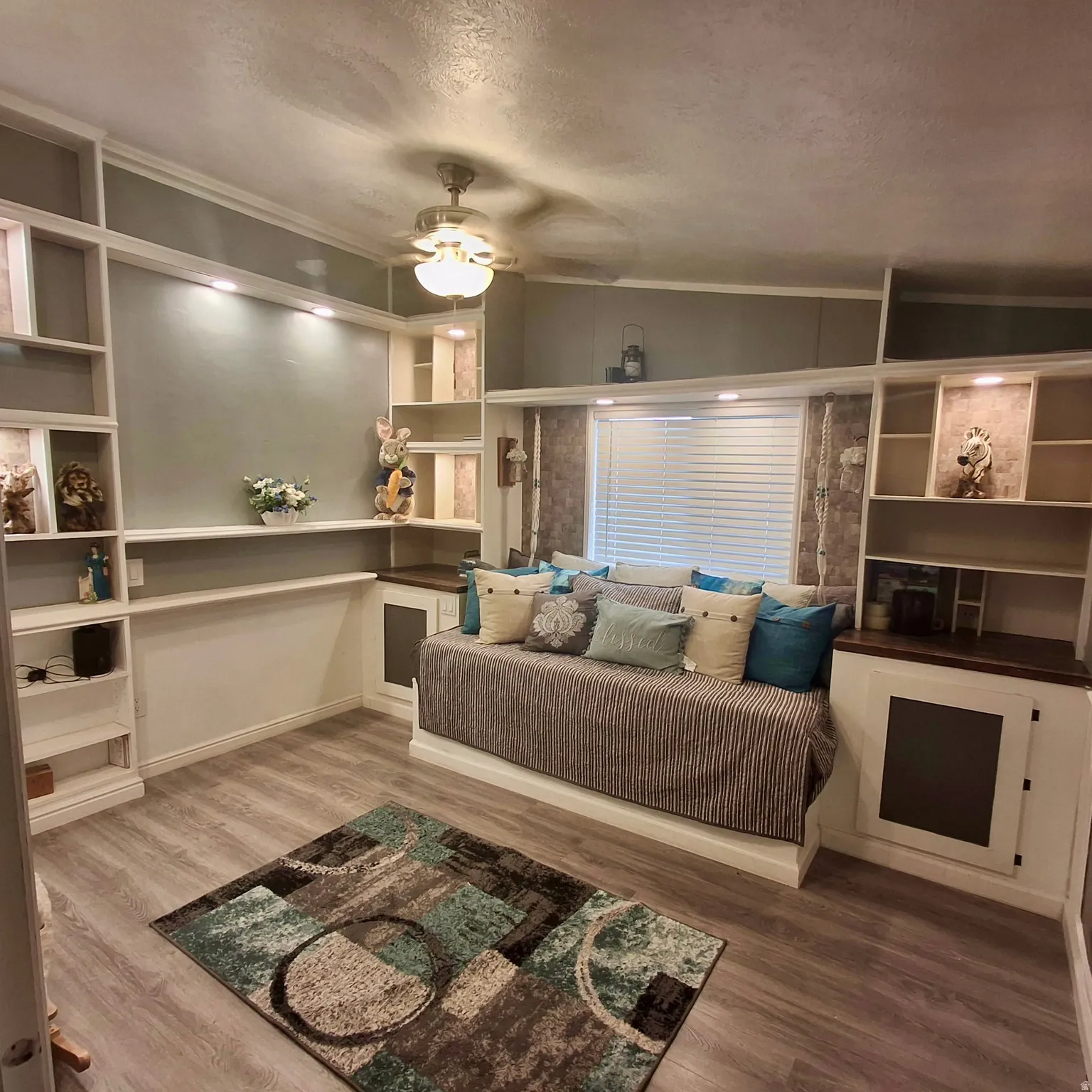 Built-in shelving and cabinetry with recessed lighting, wood-finish flooring, and a ceiling fan with integrated lighting