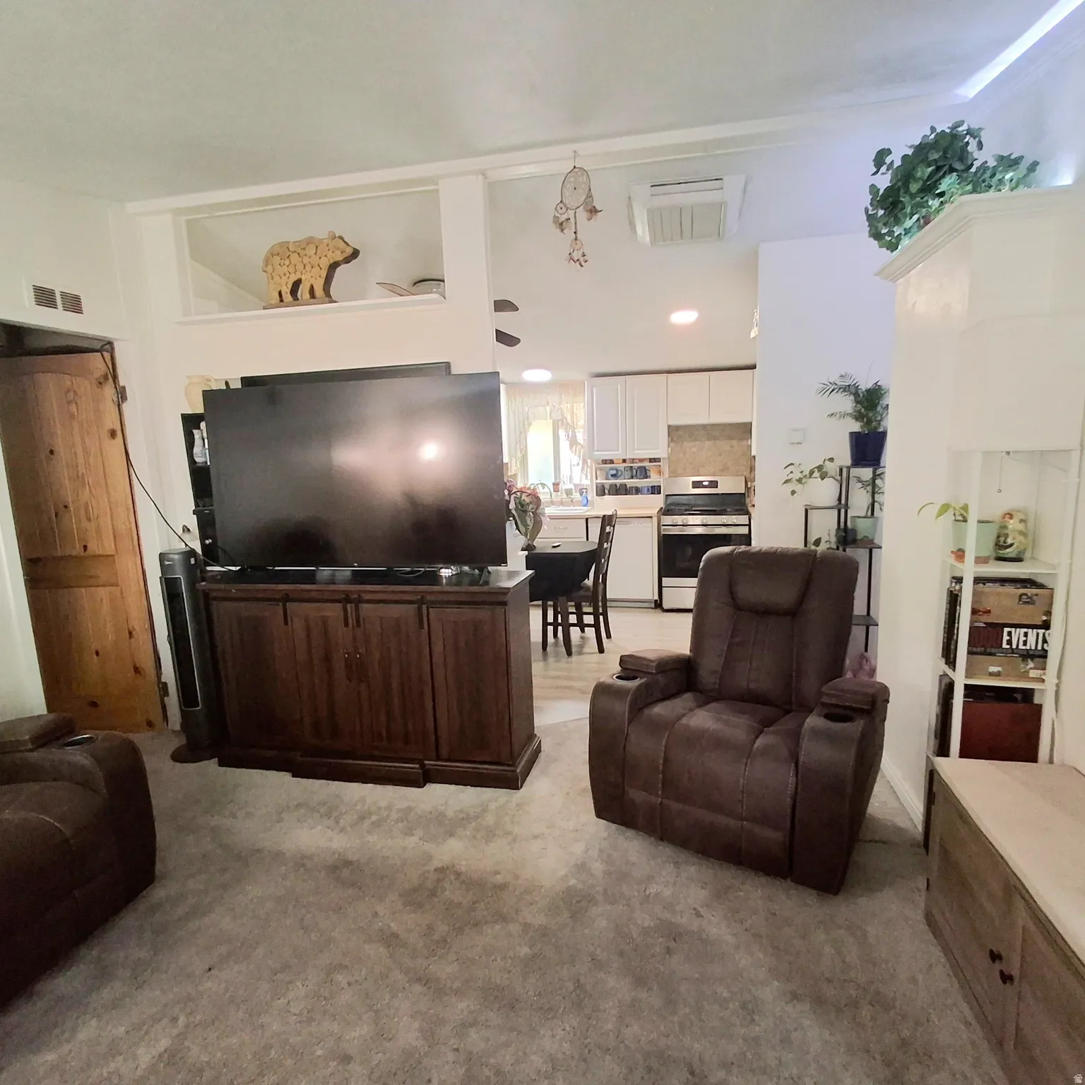 Open concept living area featuring a neutral carpeted floor and a rustic wood-finish barn door