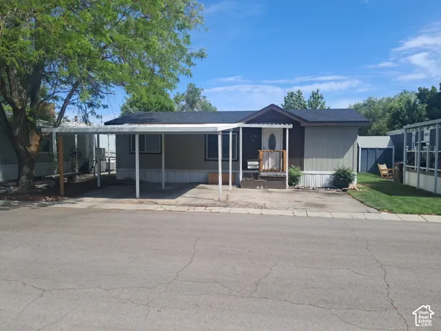 Modular home with a covered carport, porch entry, and shingled roof