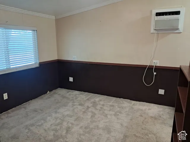 Wall-mounted air conditioning unit, gray carpet flooring, window with blinds, and two-tone wall finish