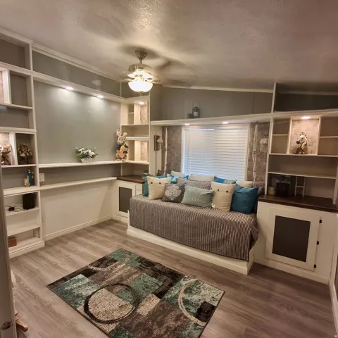 Built-in shelving and cabinetry with recessed lighting, wood-finish flooring, and a ceiling fan with integrated lighting