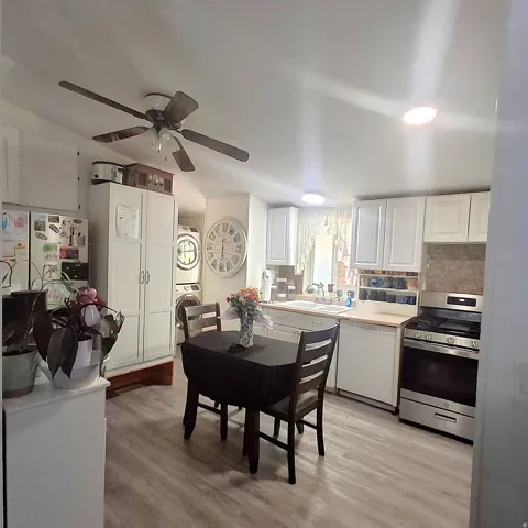Kitchen featuring wood-finish flooring, white cabinetry, and stainless steel appliances
