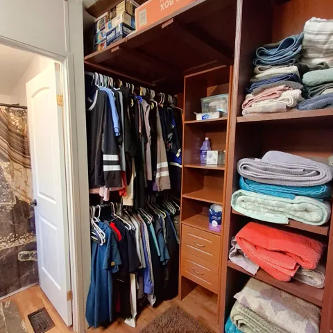 Custom closet organization system featuring rich wood-finish shelving and built-in drawers
