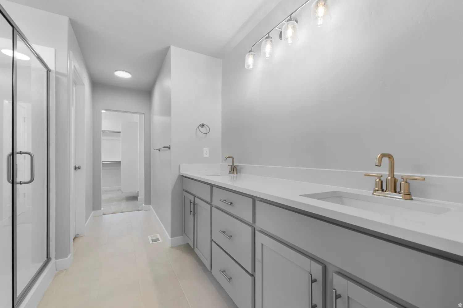 Contemporary bathroom with a double vanity featuring light gray cabinetry and white countertops