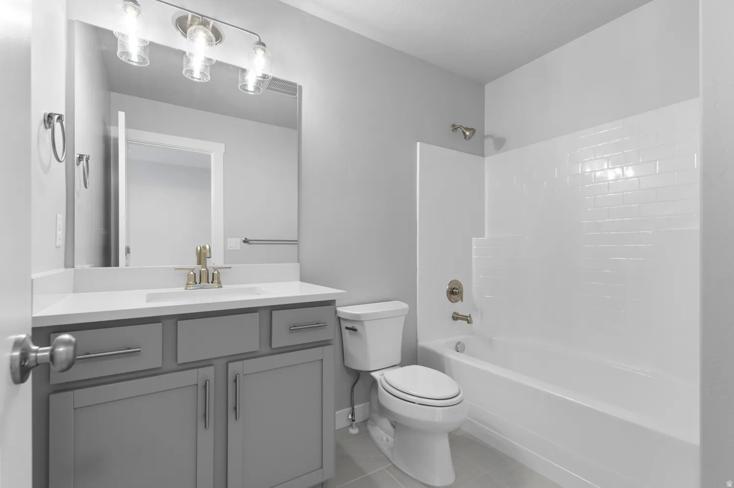 Bathroom featuring a single vanity with gray cabinetry, a white countertop, and a rectangular undermount sink